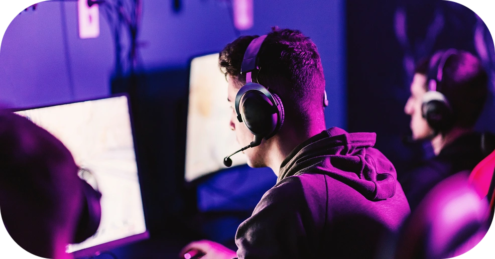 esports spelers met headsets die achter computers spelen in neonverlichting
